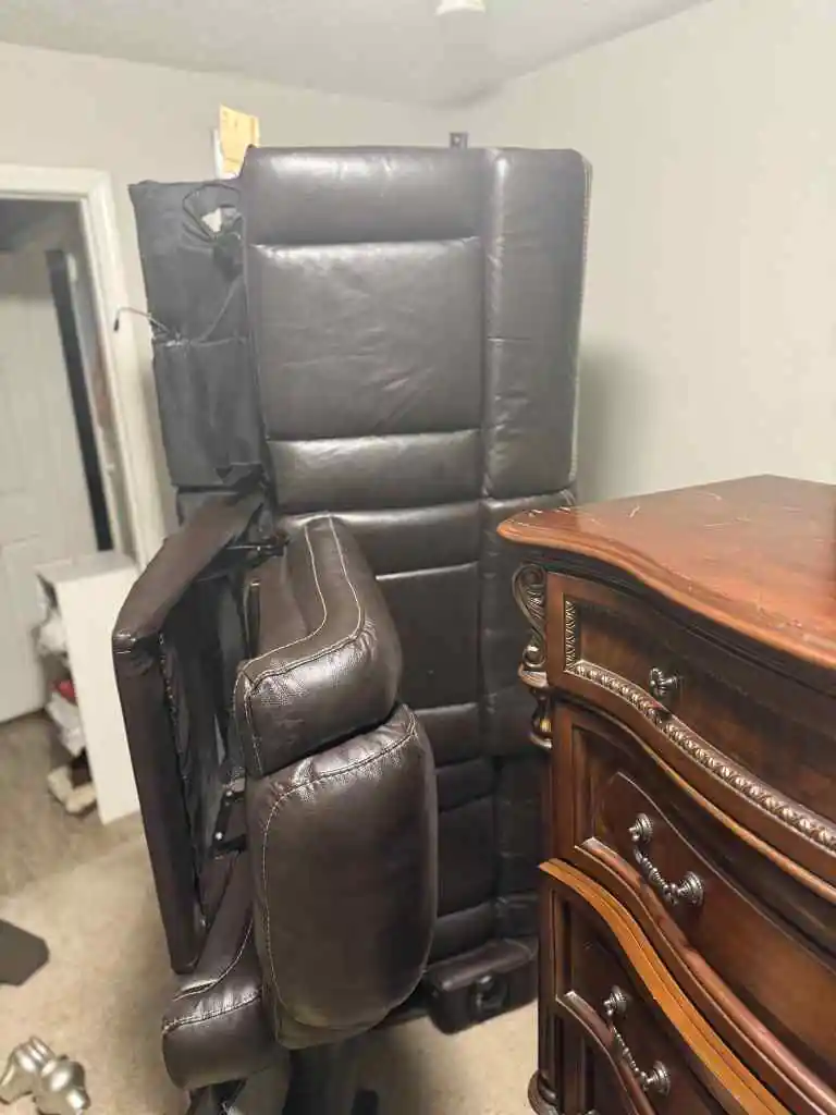 Recliner and dresser inside an apartment before pickup