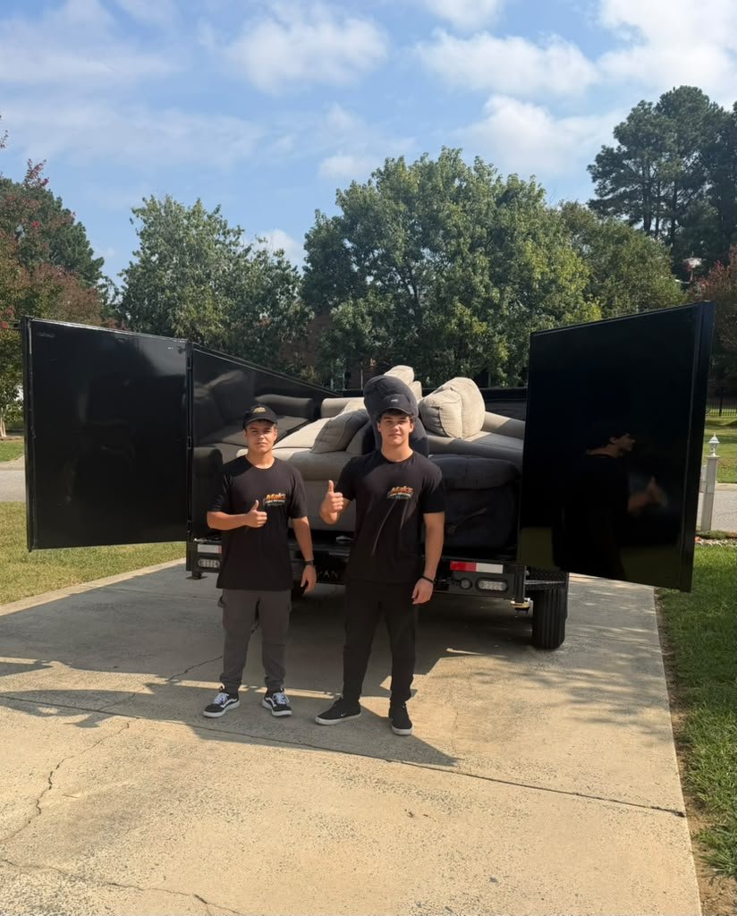 The two brothers behind Haul Fellas standing in front of their junk removal truck